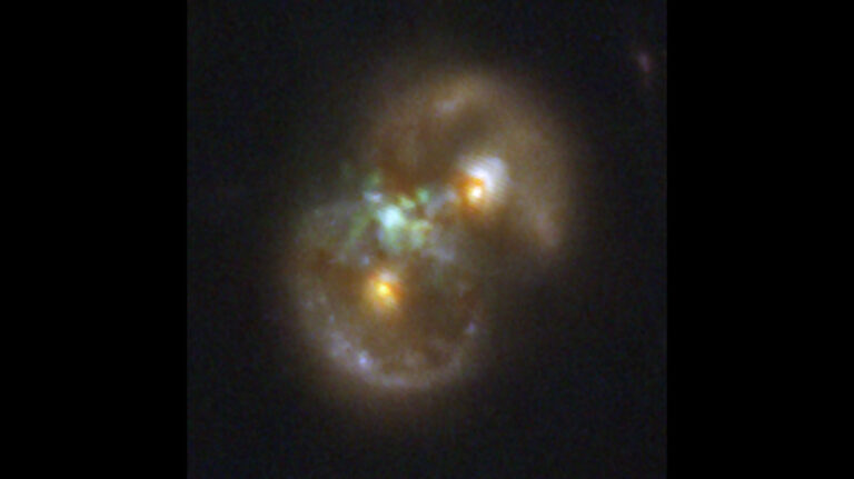 A galaxy that looks like an infinity symbol tilted so that one ring is on the bottom left and the other is on the upper right. In the middle of each ring is a dot. And near the galaxy