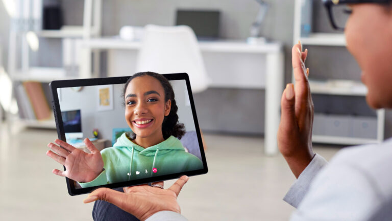 Get a sneak peek at the tech you may use in the future a person seen in profile is wearing black rimmed glasses and waving at their friend on some type of screen technology. The friend seems to pop out of the screen like a hologram.